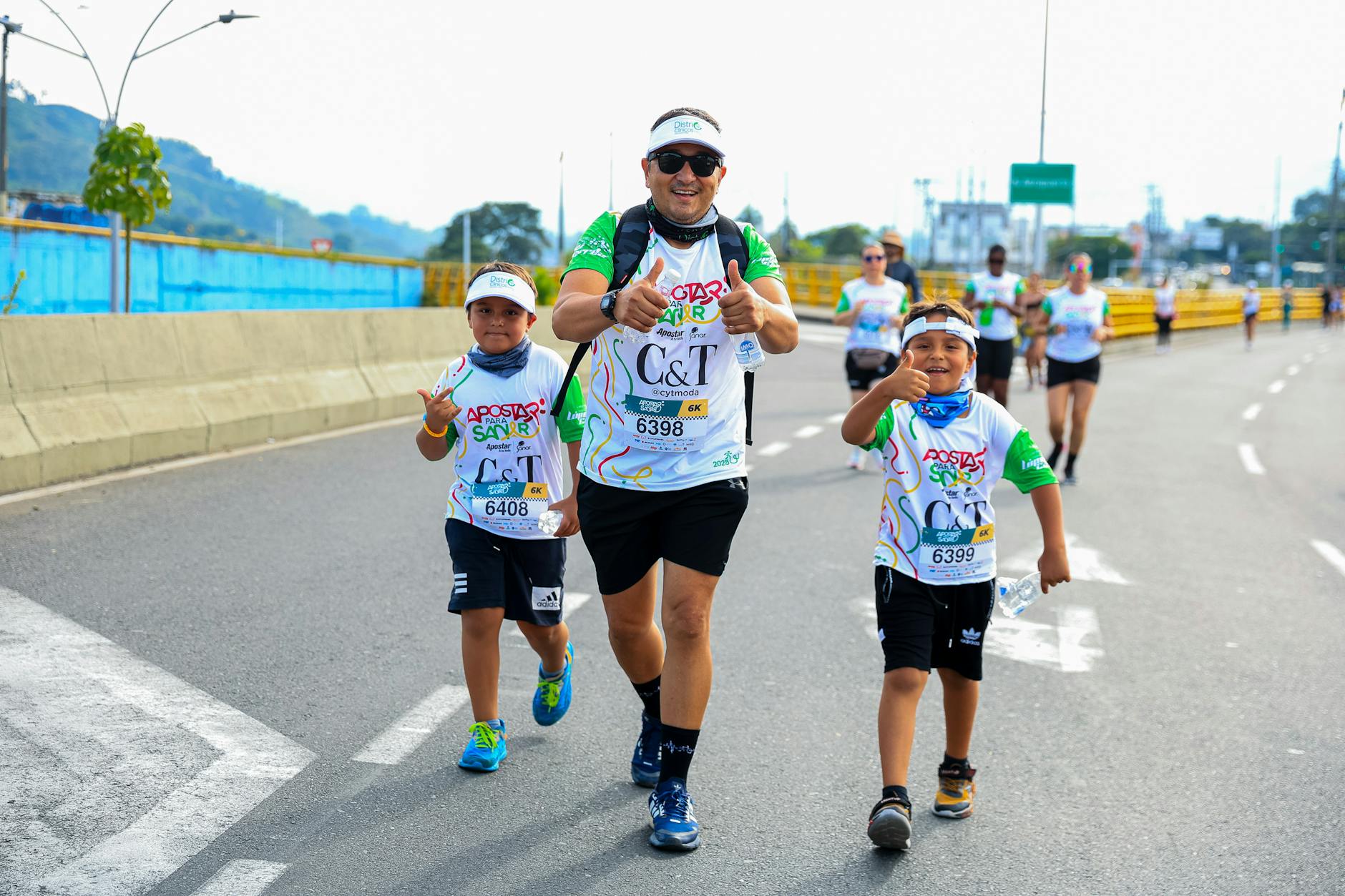 Family enjoying a fun run event together, showing thumbs up in athletic attire.