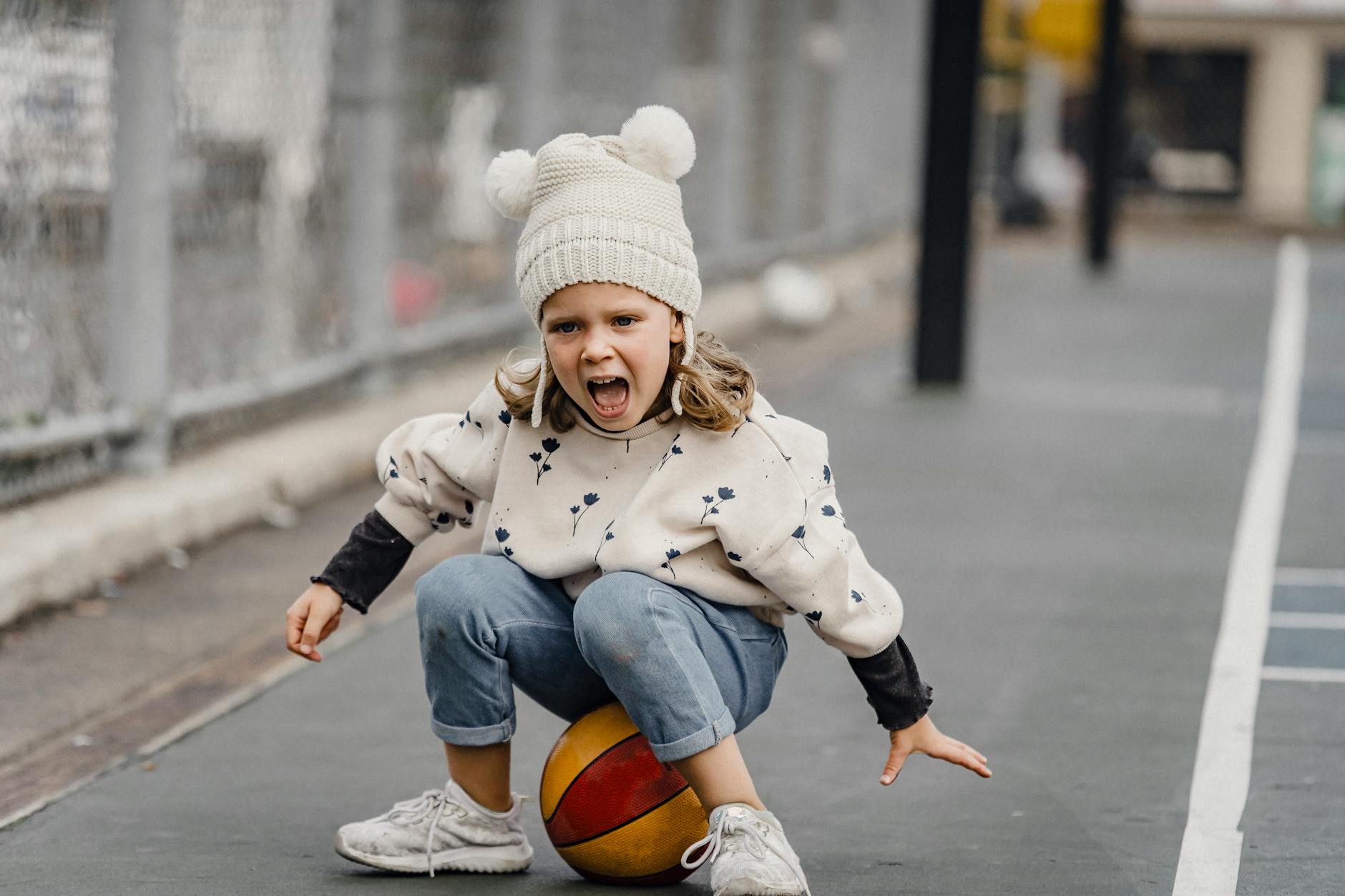 A cheerful child playing and enjoying on a sports court, full of energy and enthusiasm.