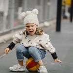 A cheerful child playing and enjoying on a sports court, full of energy and enthusiasm.