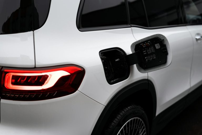 Close-up of a modern electric vehicle with an open charging port, showcasing clean design.