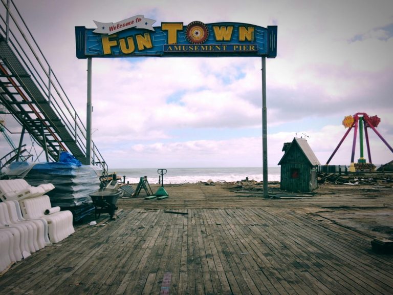 Vintage amusement park pier with empty rides and weathered boardwalk in New Jersey.
