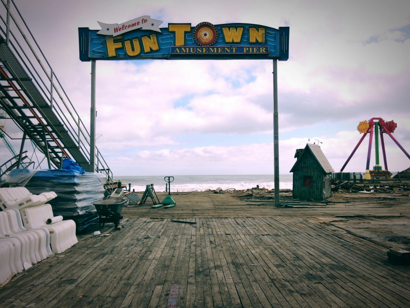 Vintage amusement park pier with empty rides and weathered boardwalk in New Jersey.