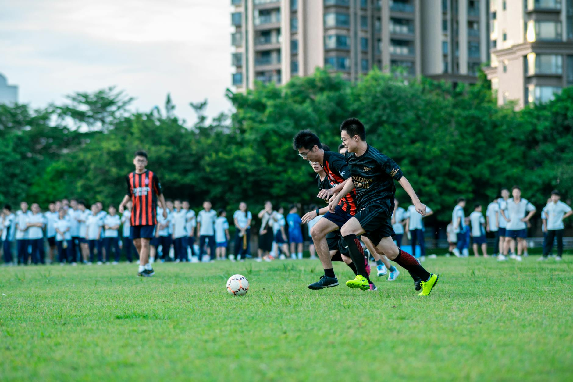 Dynamic soccer game capturing two young players in action on a grassy field surrounded by spectators.